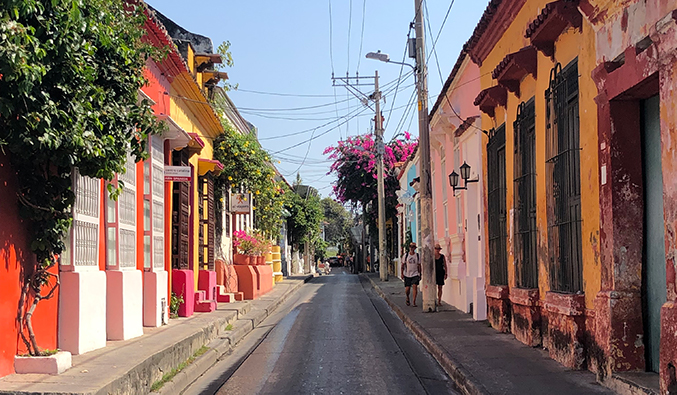 Brightly painted buildings along a narrow, empty street in Cartagena, Colombia