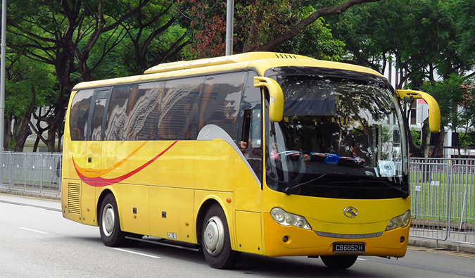 a yellow tourist coach bus in Southeast Asia