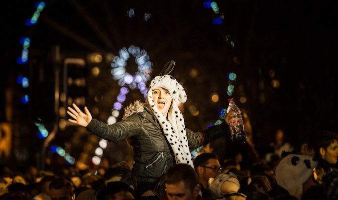 Girl partying in the crowd at Hogmanay, all bundled up