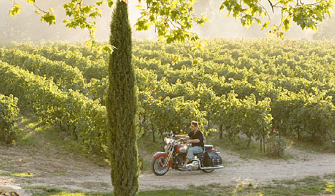 Russell Crowe riding a motorbike in the vineyard in A Good Year