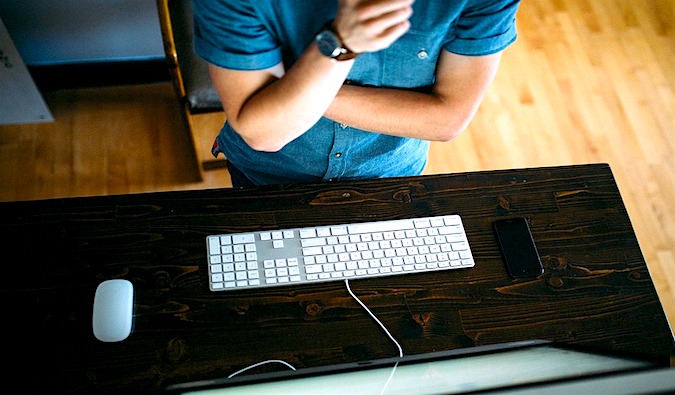 a travel blogger sitting at a desk working on their laptop