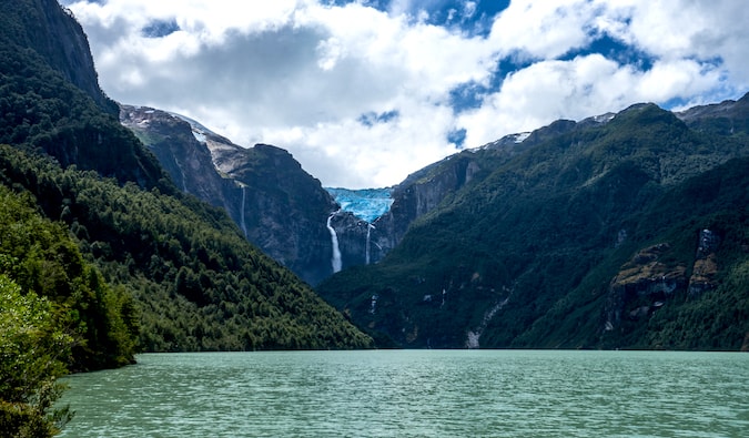 Queulat Glacier surrounded by turquoise waters and lush, green forests