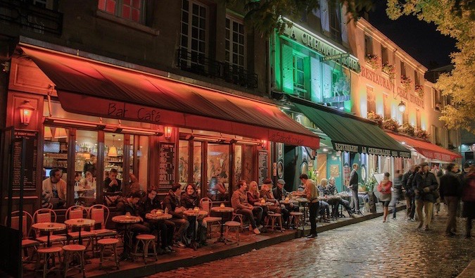 Busy bars and cafes in Paris, France lit up at night