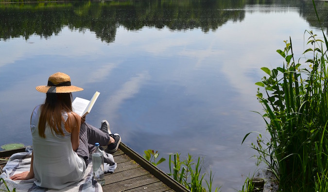 girl sitting outdoors reading travel books