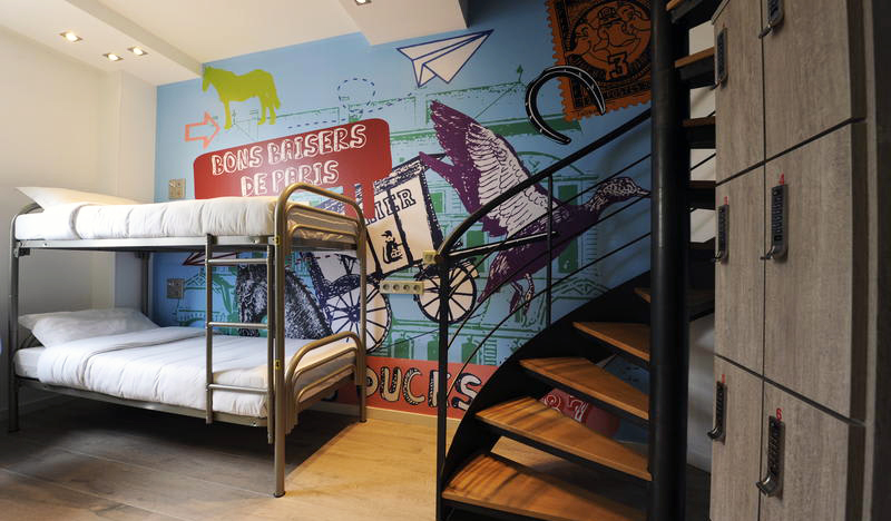 room with bunk bed, brightly decorated wall, and a spiral staircase at 3 Ducks Hostel in Paris