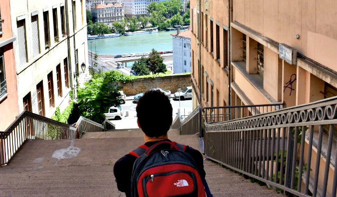 Nomadic Matt sitting on a staircase outside in Europe