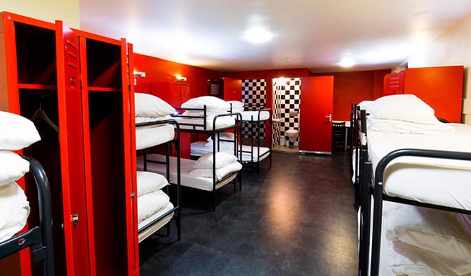 Dorm room with bright red walls and many bunk beds at The Bulldog Hotel