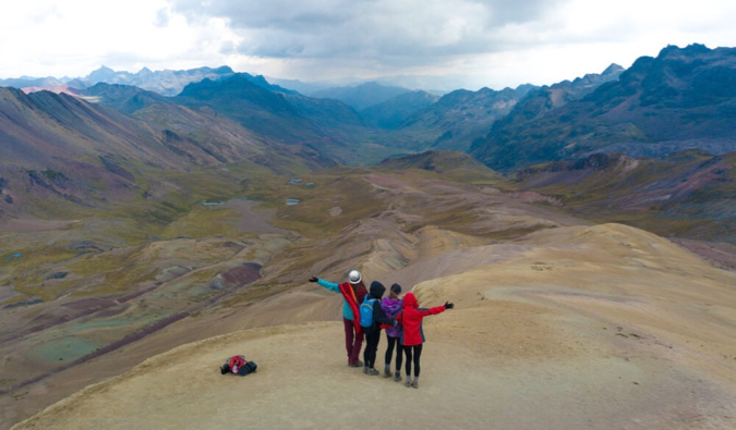 A group of solo female travelers hiking together in the mountains