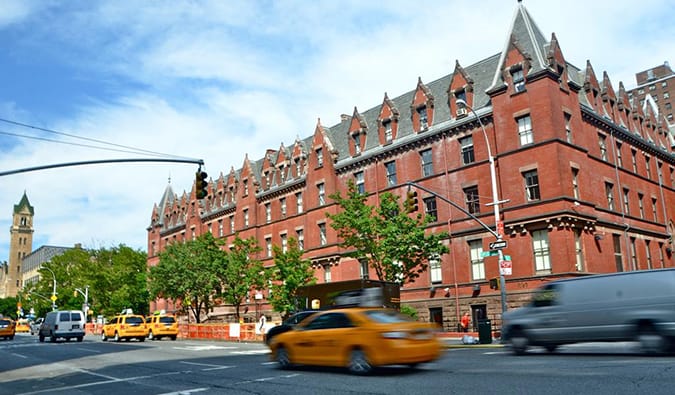 Large brick building with yellow cabs going by at HI New York in NYC