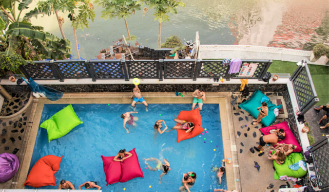 Birdseye view of people hanging out at the pool at Mad Monkey Hostel