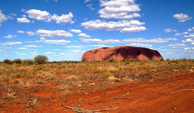 Uluru surrounded by desert in Australia on a bright summer day