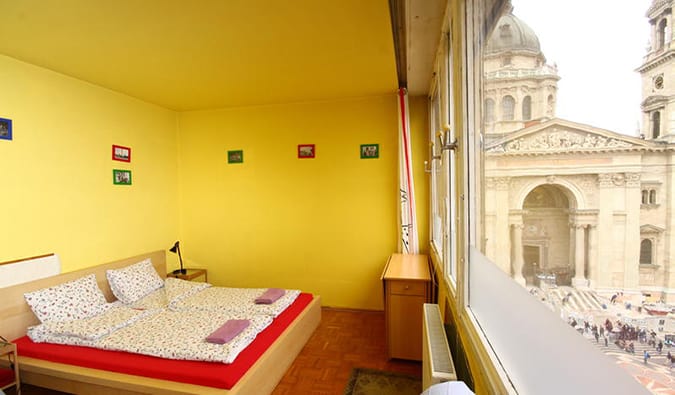 Brightly colored double room with window looking out over the city at Pal's Hostel, Budapest