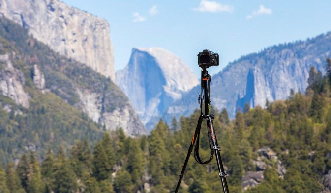 Camera and tripod set up in front of a mountain and nature in Yosemite National Park