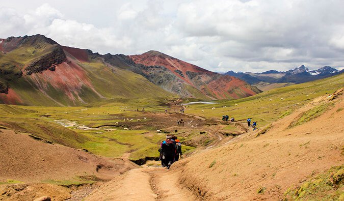 hikers walking through a trail on Rainbow Mountain