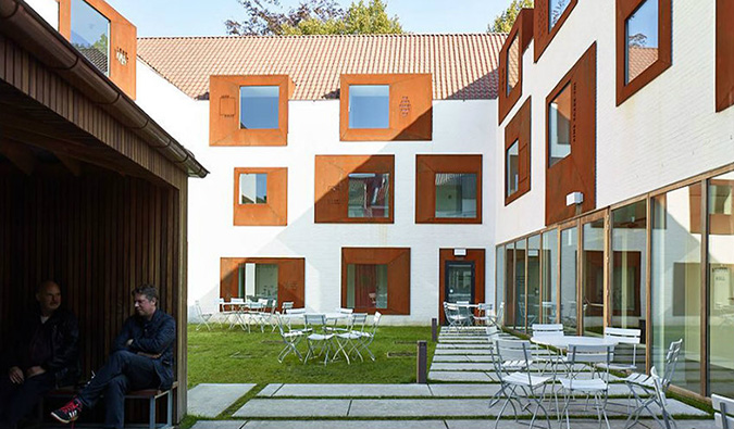 Interior courtyard with tables and chairs at Snuffel Hostel in Bruges