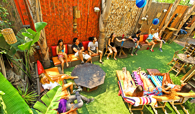 Lots of people hanging out and lounging on outdoor couches and lawn chairs at Banana Bungalow Hollywood in Los Angeles