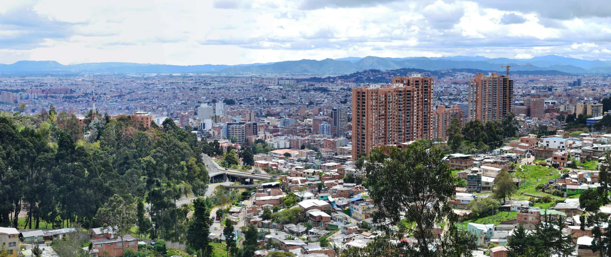 A city view of Bogotá, Colombia with lush greenery and rolling mountains in the background