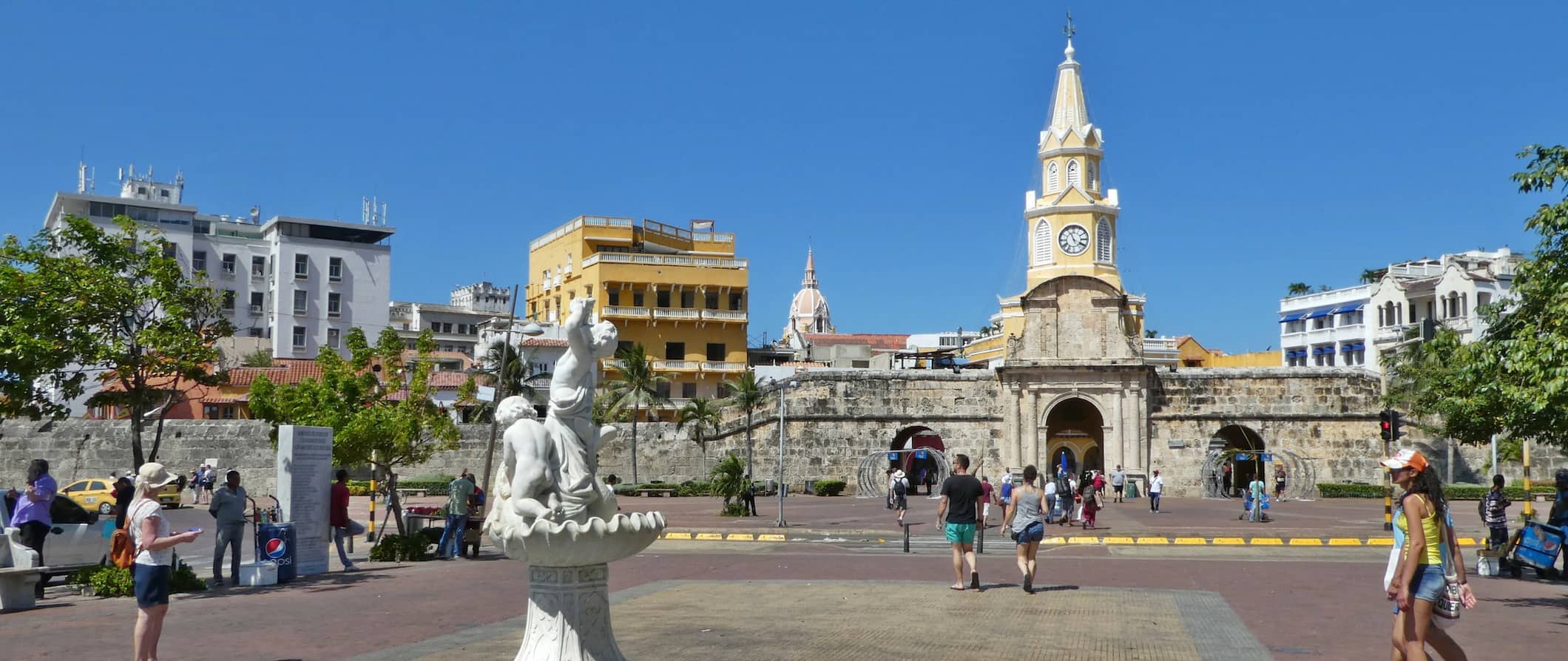 The Old Walled City in Cartagena, Colombia filled with people on a bright and sunny day