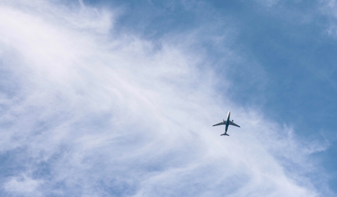 A commercial jet flying high in the bright blue sky