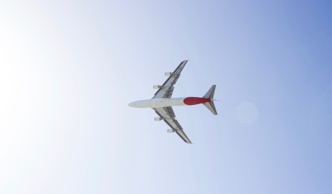 A photo looking up at a huge airplane flying in the sky