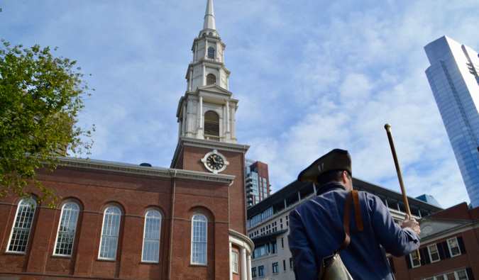 a historical actor leading a walking tour in Boston, USA on a sunny summer day