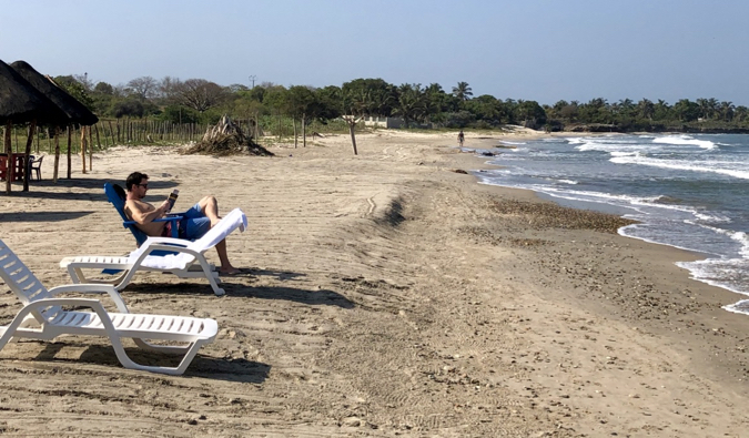 A sandy beach with a couple of tourists relaxing on a sunny day in Cartagena