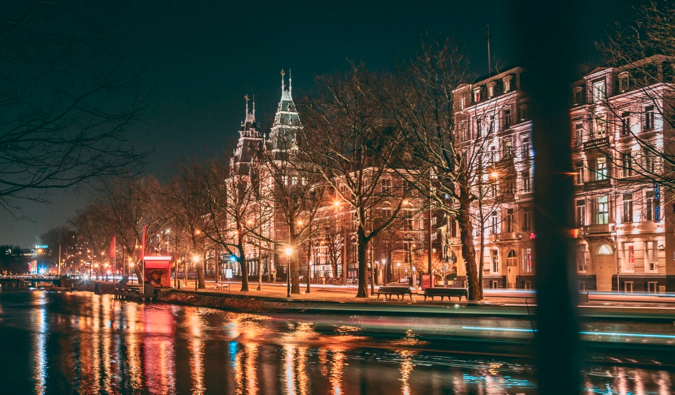 The busy streets and old buildings of Amsterdam at night