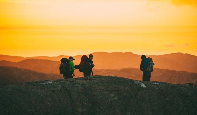 a group of travelers hiking at sunset in Norway