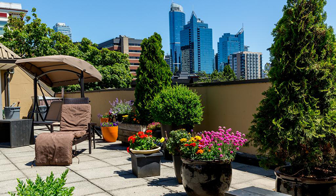 Rooftop terrace with loungers and skyscrapers in the background at HI Vancouver Downtown, Vancouver