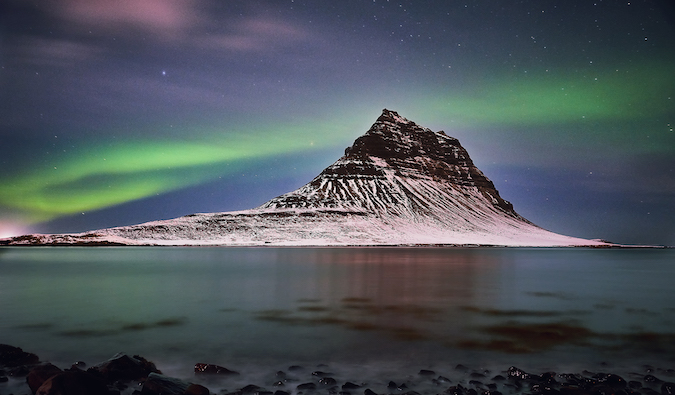 a mountain peak in Iceland under the Northern Lights