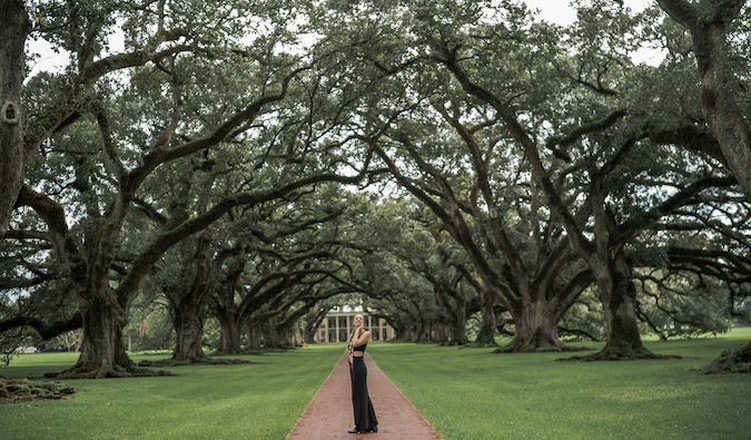 Kristin Addis on a walkway covered in tall trees