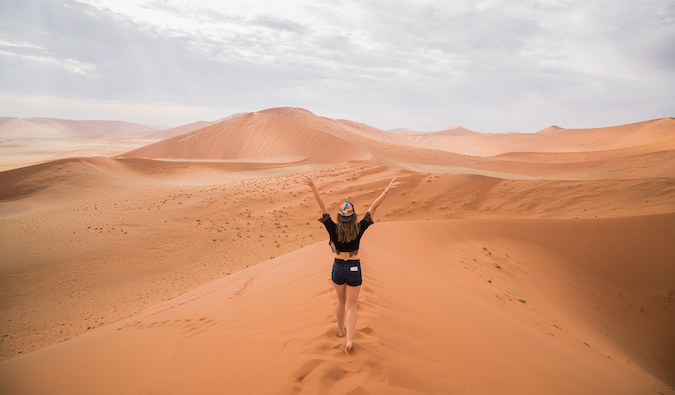 Kristin Addis walking across sand dunes in the desert