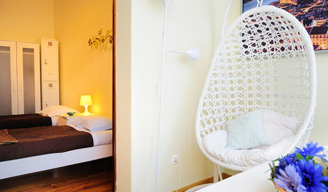 Single twin beds and wicker hanging chair in a room at Lisboa Central Hostel