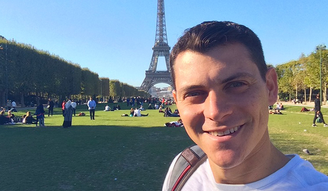 Nomadic Matt posing in front of the Eiffel Tower