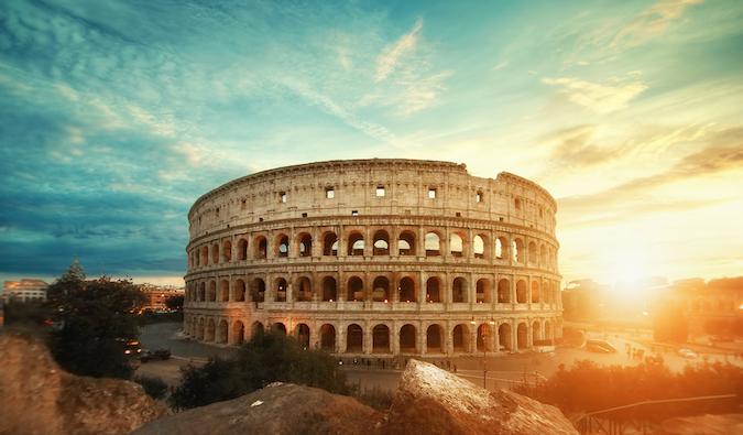 the ancient and iconic Colosseum of Rome, Italy during a bright sunrise over the city