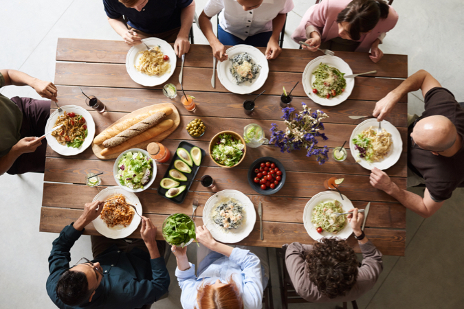 A group of travelers using the sharing economy to have a meal together