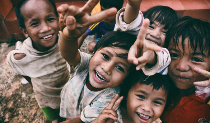 A group of young kids in Southeast Asia posing for a picture