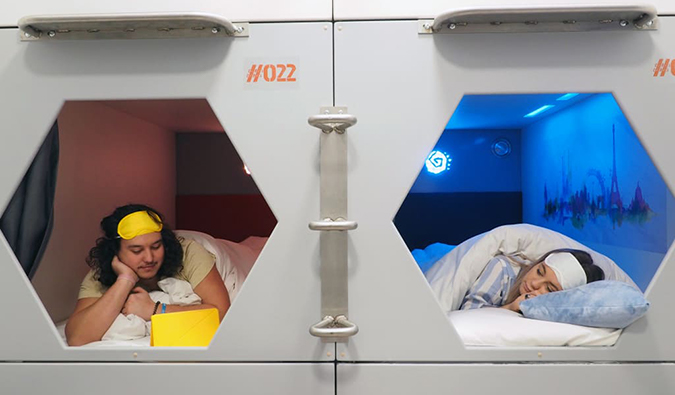 People lying in individual sleeping pods at St. Christopher's Village, London