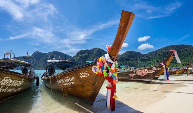 Koh Phi Phi的Longtail小船停放在一片明亮的蓝天前面的沙子在泰国