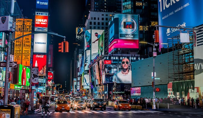 Times Square in NYC lit up at night and bustling with people