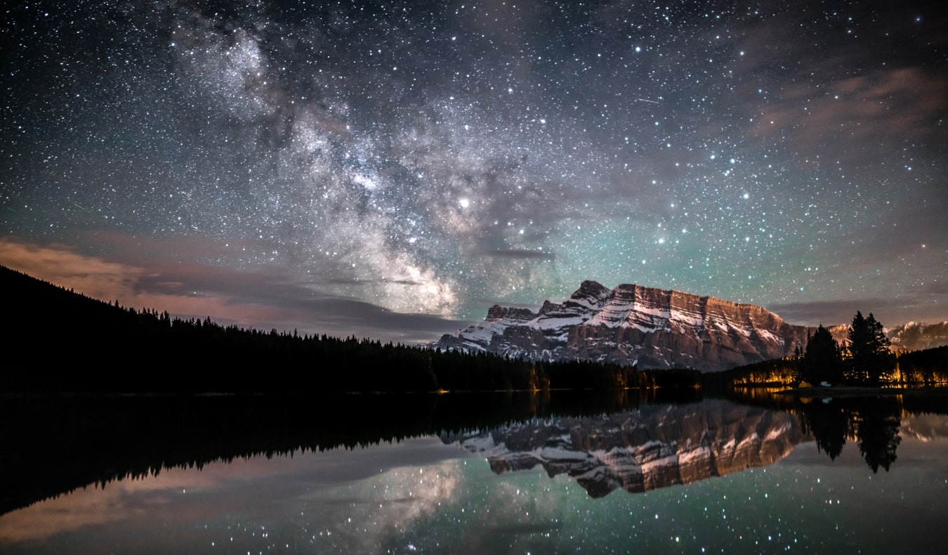 Lake Louise and Banff at night under a starry sky