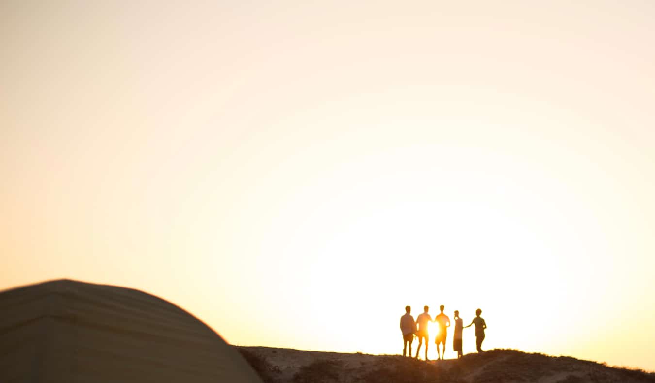 A group of travelers on a mountain during sunrise