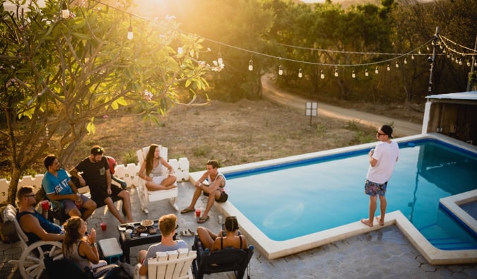 A group of upkeep backpackers relaxing at a pool in a hostel in Central America