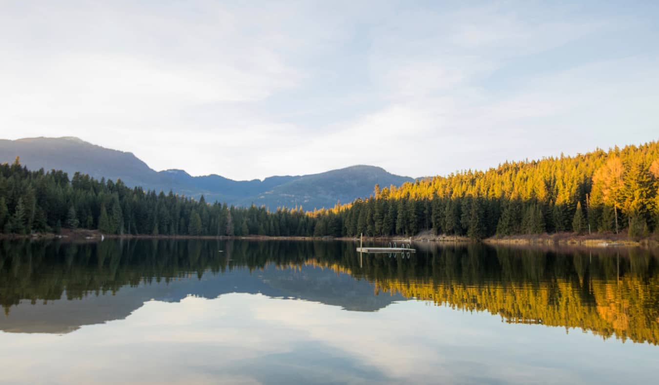 A calm lake with a small floating dock near Whistler, BC, Canada