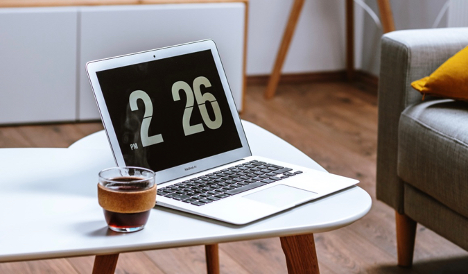 A laptop and a coffee resting on a table