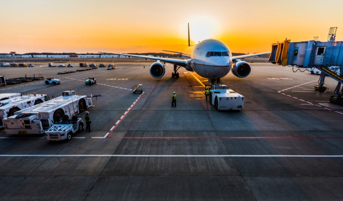 A solitary airplane at an airport during sunset