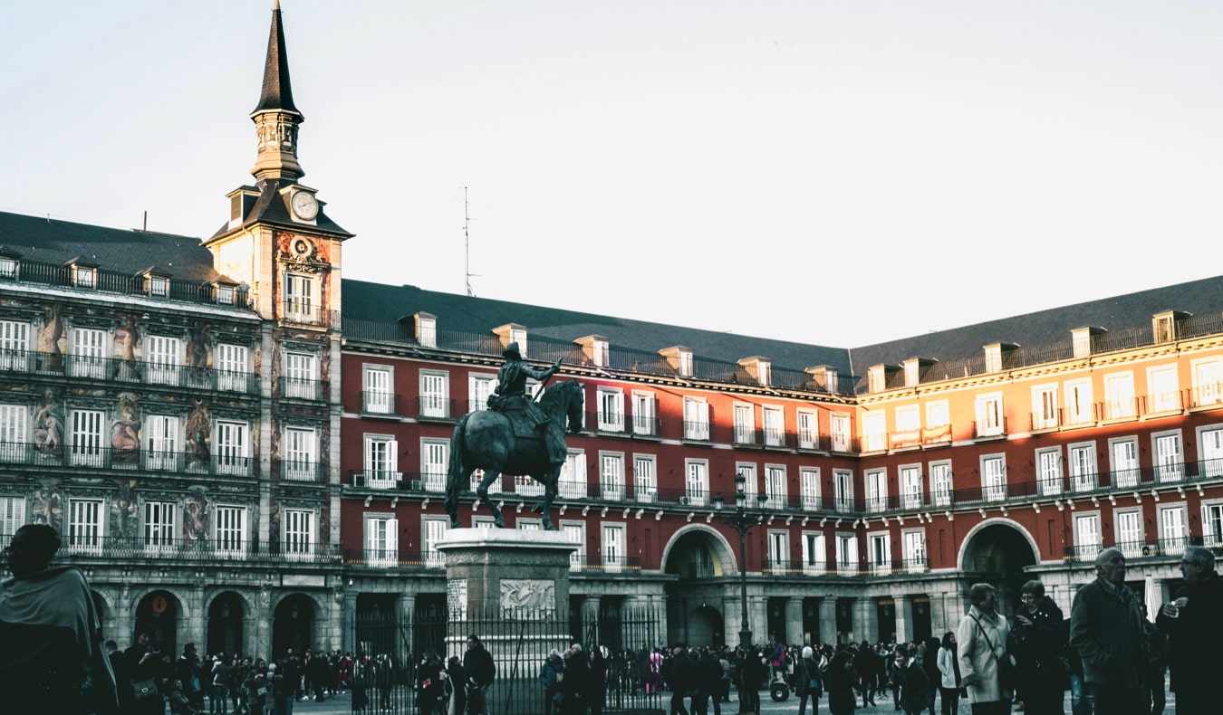 Travelers exploring a historic plaza in Madrid, Spain