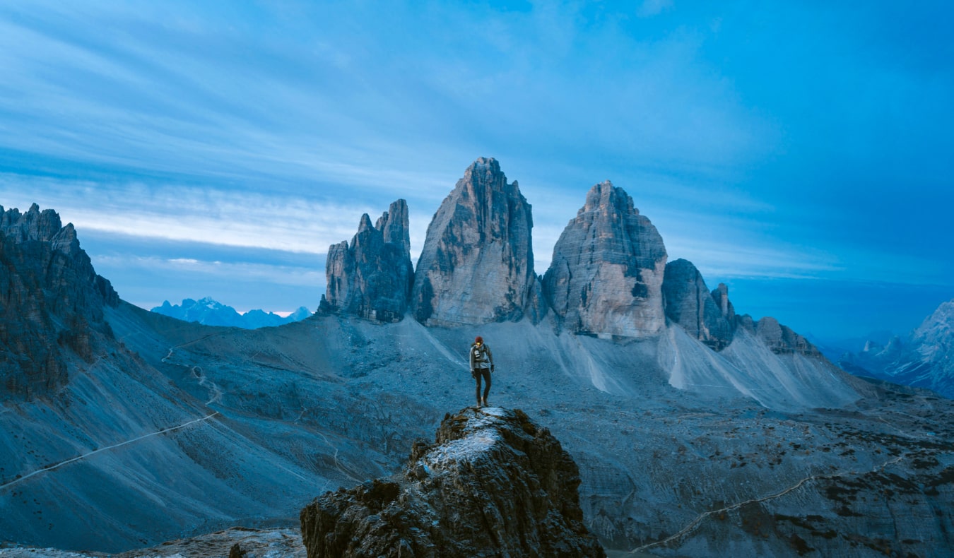 Un voyageur solitaire se tenant sur une montagne et regardant au loin.
