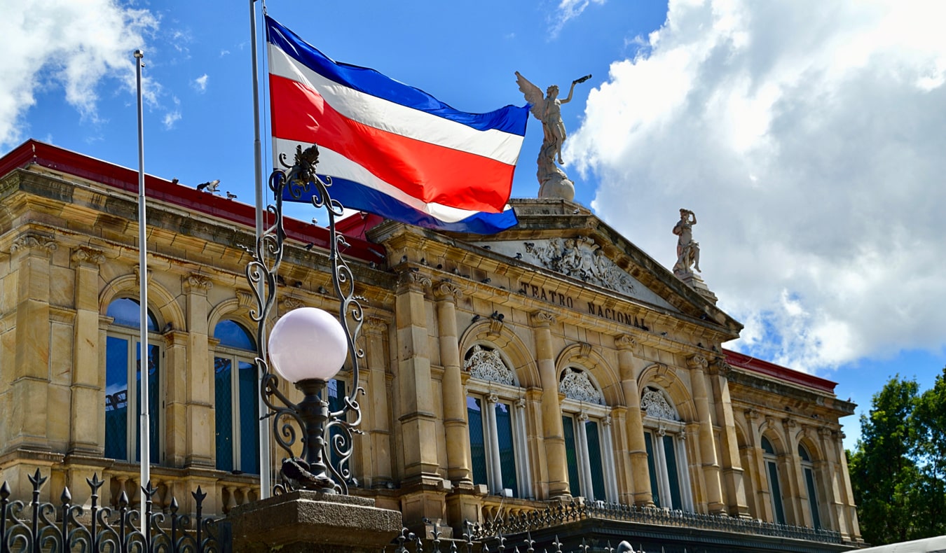 The Costa Rican flag waving in front of the historic theaer in San José, Costa Rica