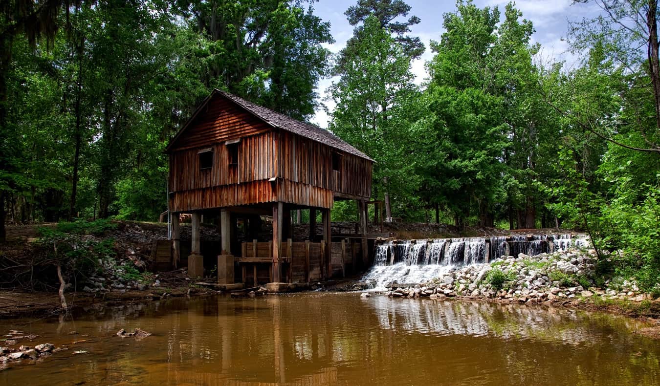 An old wooden building beside a river in the American South